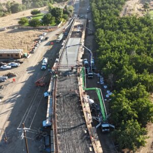 A high view vertical view of the bridge as the first half shows the metal rebar and second half is filled concrete.
