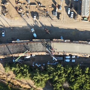 An aerial view of a bridge that is half filled with smooth concrete and other half showing the metal rebar.