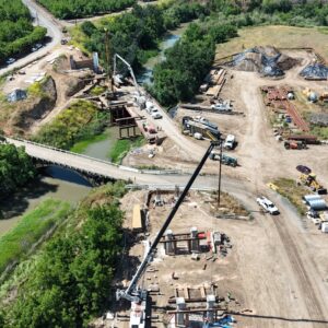 A bridge leading to construction on both sides with pairs of abutments and equipment.