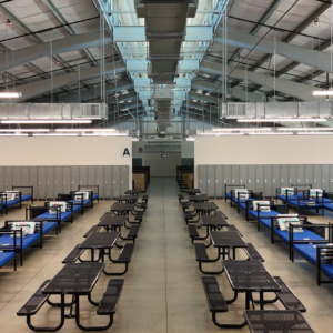 The interior of the metal facility with lined benches and beds.