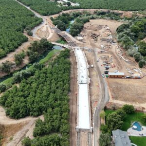 High aerial view of half the bridge poured and the other half with foundational beams.