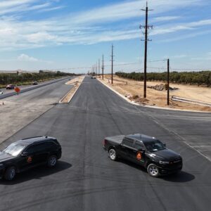 Two CCME cars parked facing the opposite way on a completed paved roadway
